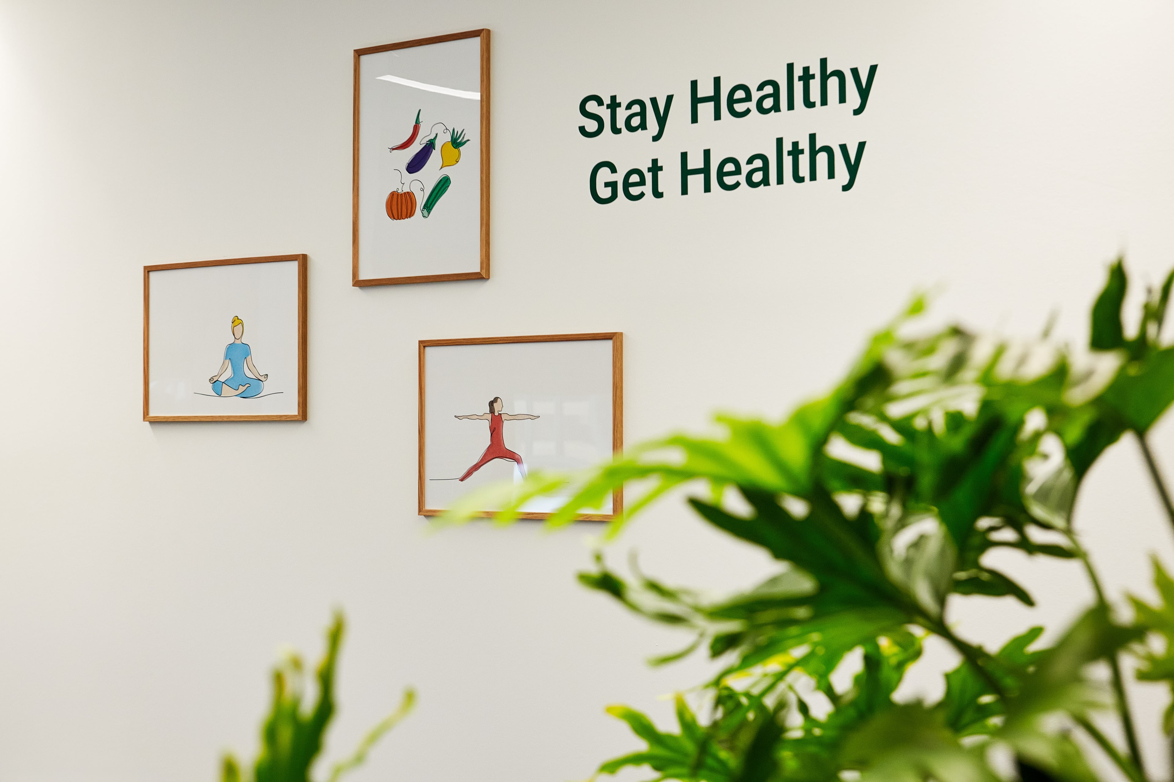 Wall with illustrations representing nutrition, exercise, and mindfulness alongside the words ‘Stay Healthy Get Healthy.