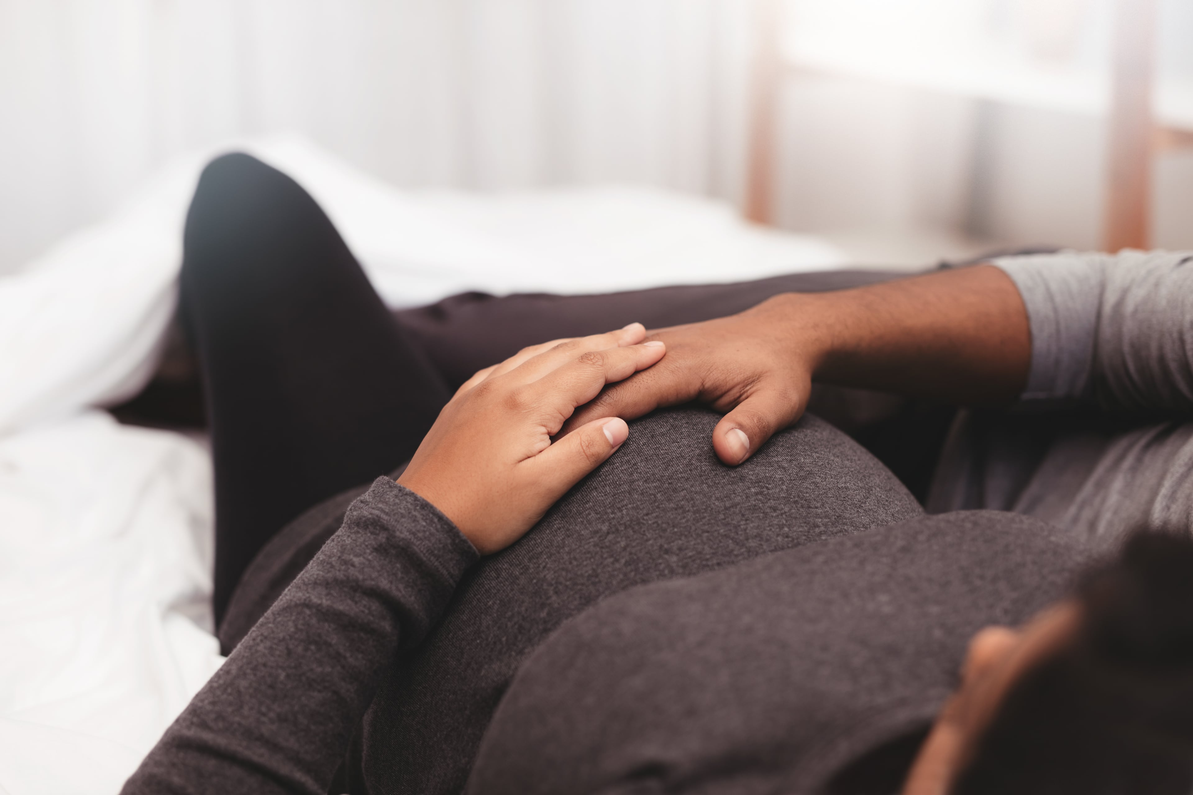 Schwangere Frau greift sich auf Babybauch