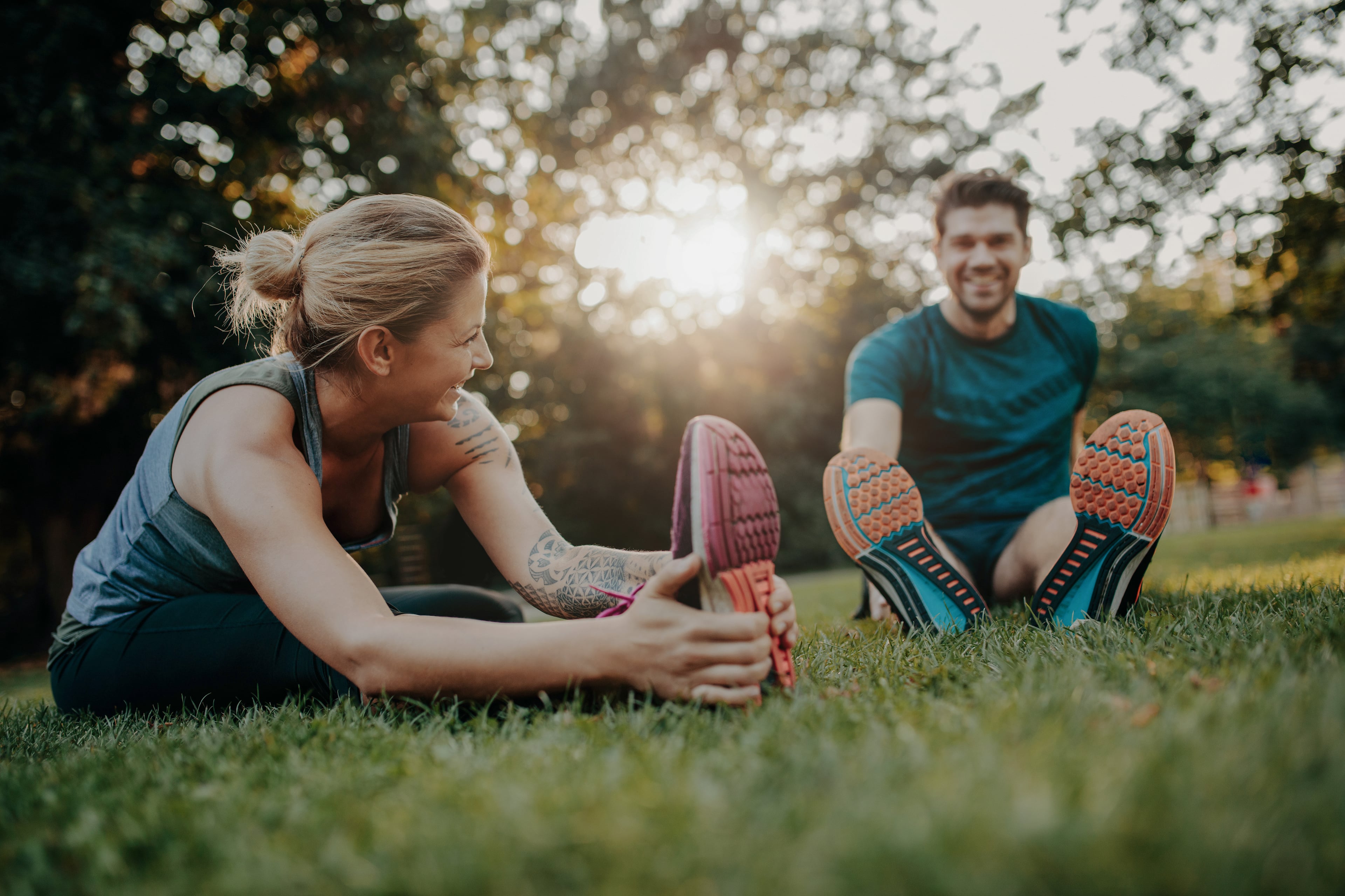 Mann und Frau beim Stretching in einem Park