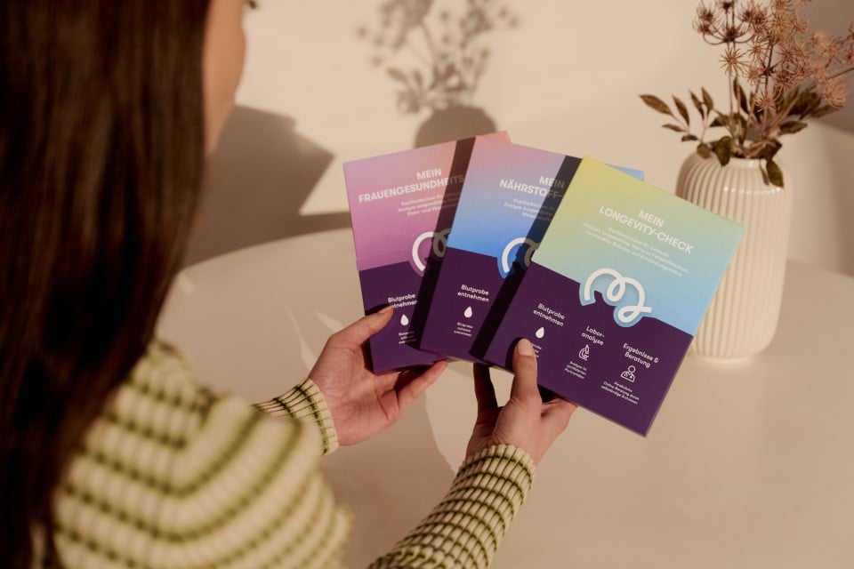 Person holding Mavie health test kits for nutrient analysis, longevity check, and women’s health